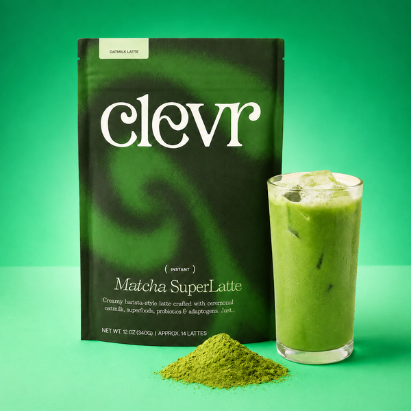 A package of clevr Matcha SuperLatte instant coffee stands next to a glass of green iced latte and a small pile of green matcha powder on a bright green background.