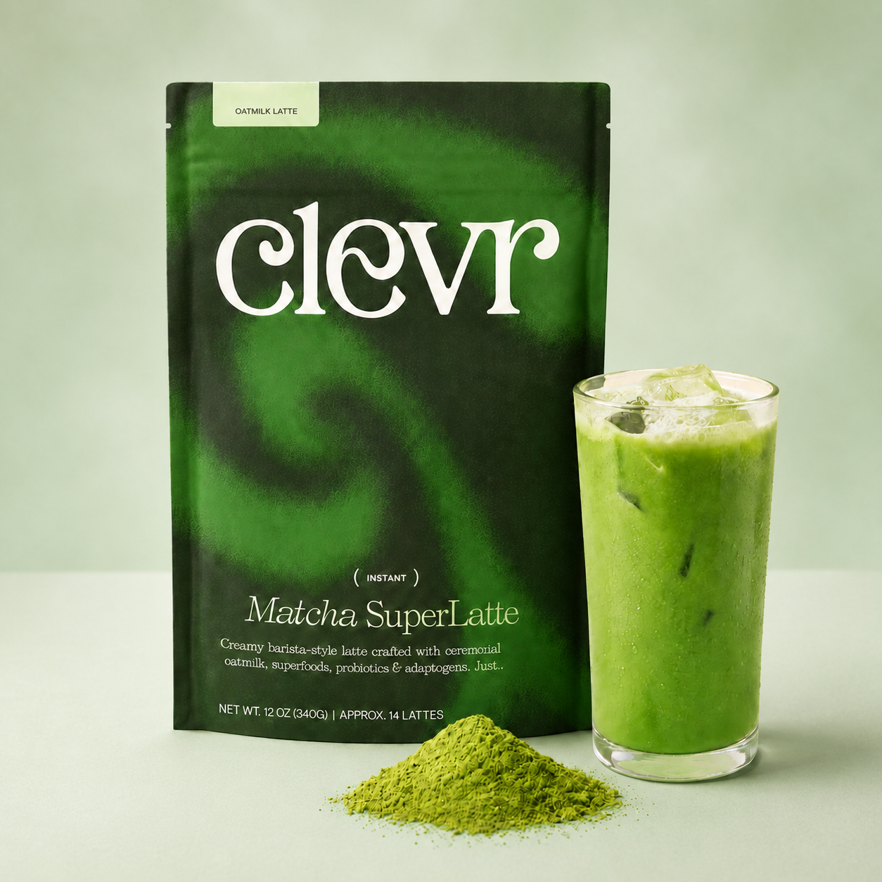 A package of clevr Matcha SuperLatte stands next to a glass of green iced latte with a small pile of green matcha powder in front, on a light green background.