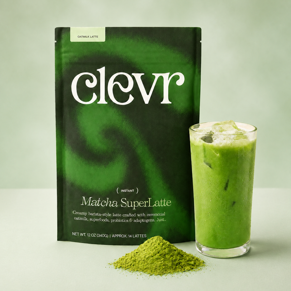 A package of clevr Matcha SuperLatte stands next to a glass of green iced latte with a small pile of green matcha powder in front, on a light green background.
