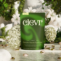 Clevr Pistachio Matcha bag with pistachios on the ground and flowers in the background.