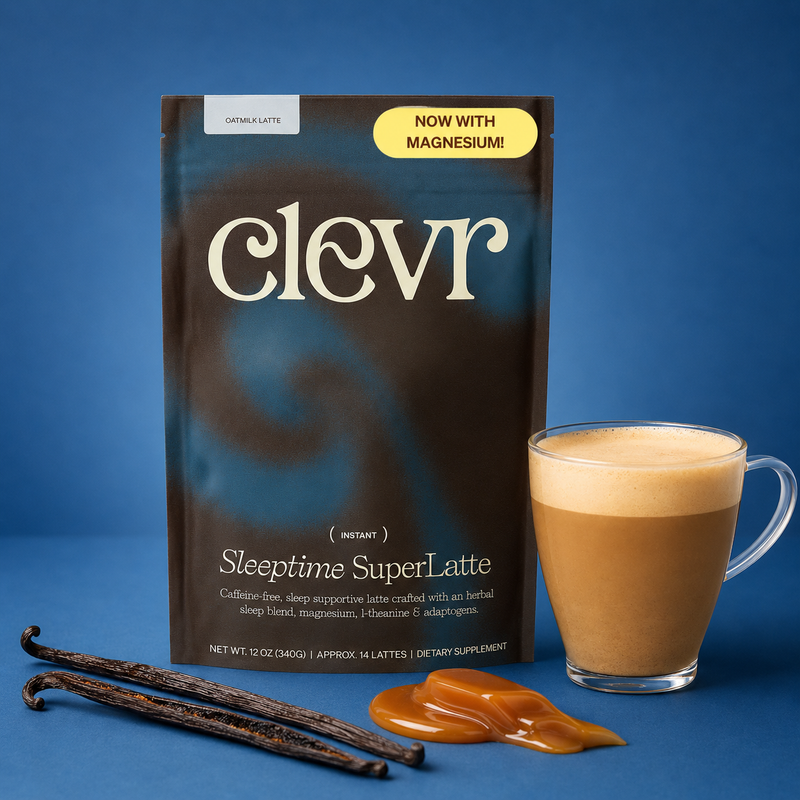 A package of Clevr Sleeptime SuperLatte instant coffee is shown on a blue background next to a glass of creamy latte, vanilla beans, and caramel drizzle. The package is dark brown and black with white text and a yellow 'NOW WITH MAGNESIUM!' badge.