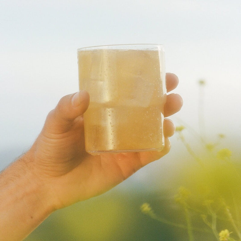Image of hand holding Clevr Yuzu SuperTea outside